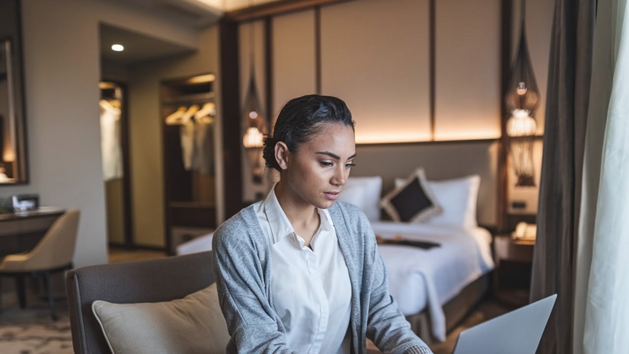 Alexis working on her laptop in a softly lit room