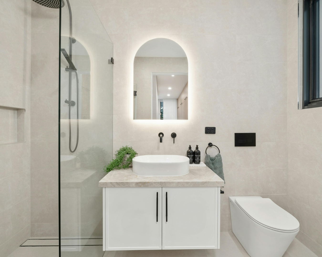 Modern bathroom remodel featuring walk-in shower, custom tile installation, and updated vanity with contemporary fixtures.