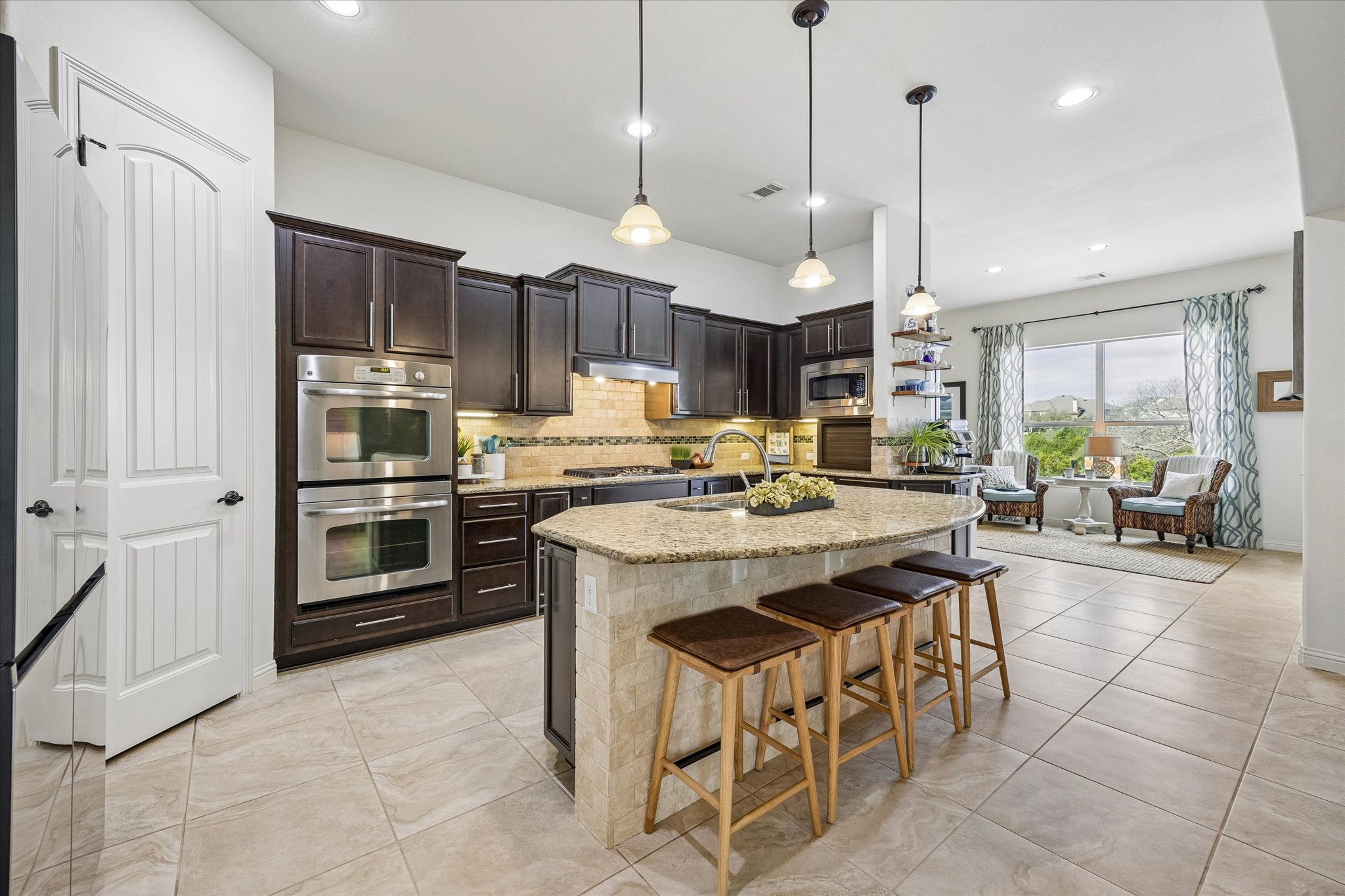 Chef's kitchen with massive granite island and stainless appliances