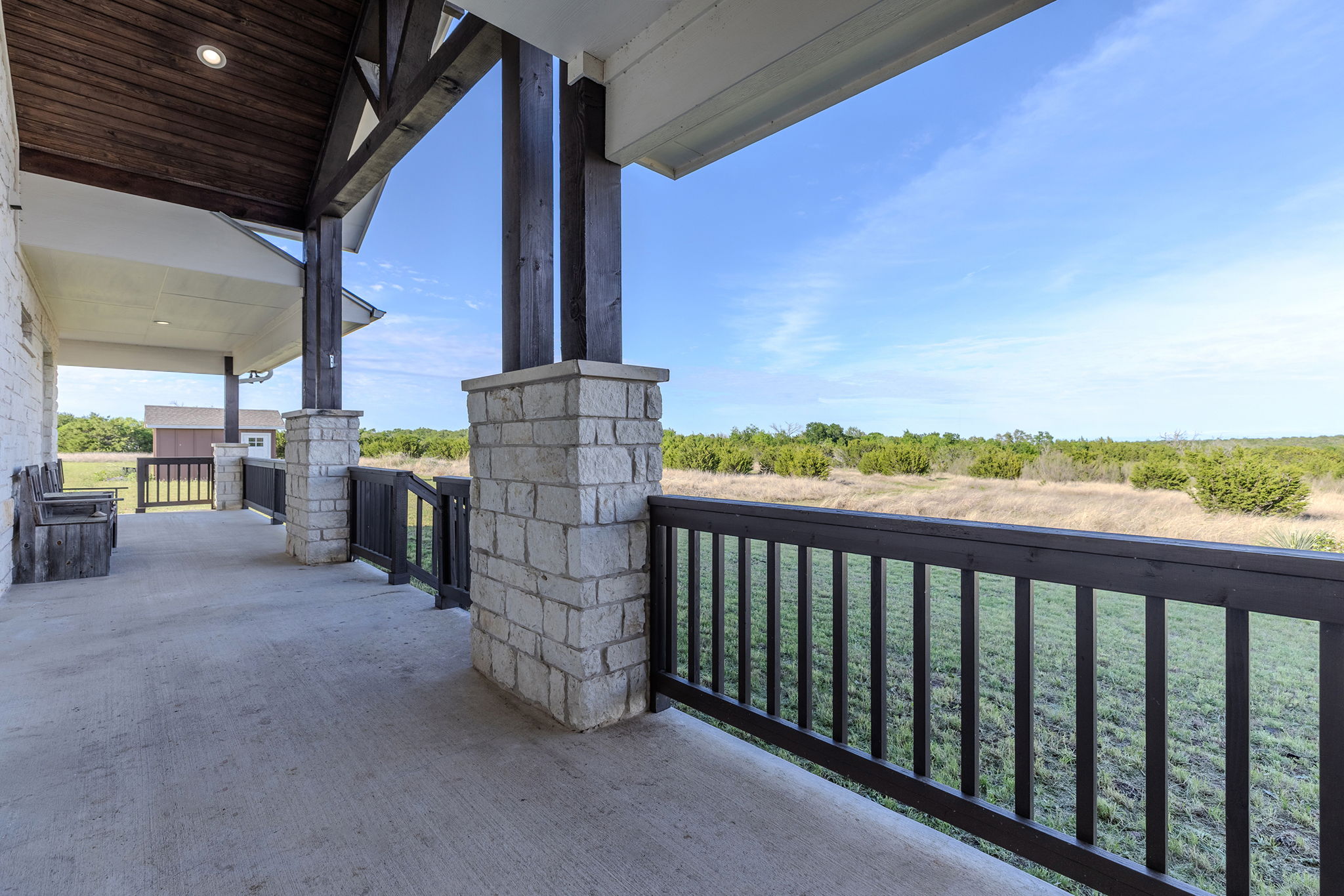 Covered porch with stone columns and Hill Country views
