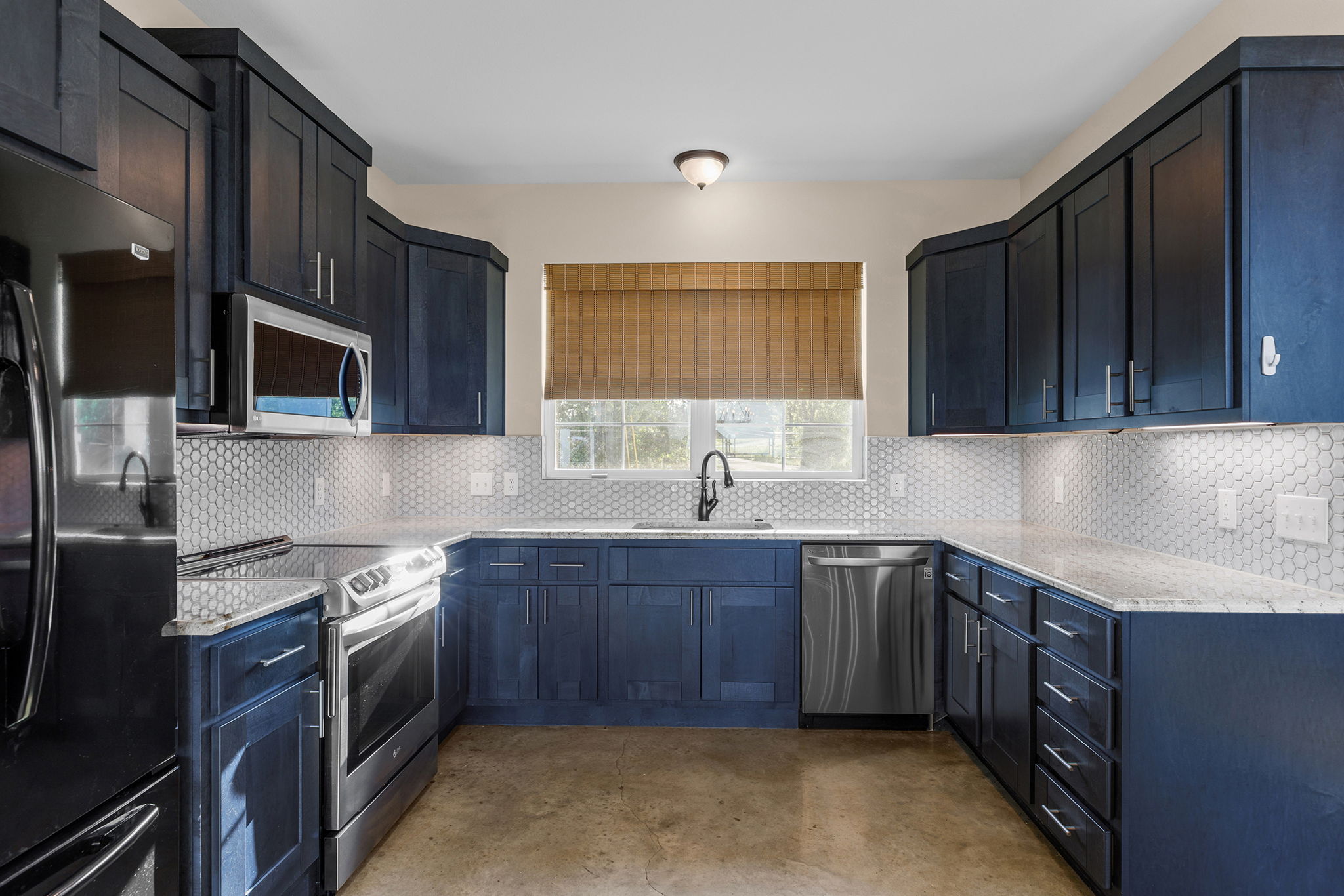 Kitchen close-up with navy cabinets and hex tile backsplash