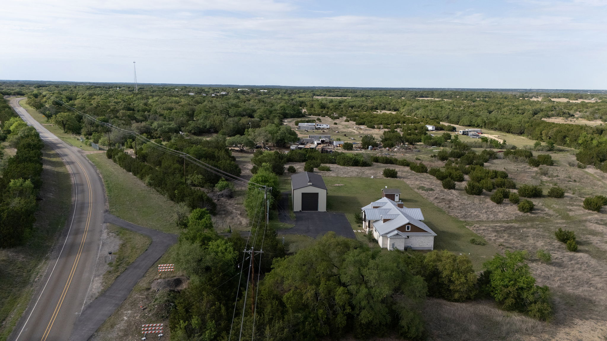 Aerial property overview showing house, garage, and road