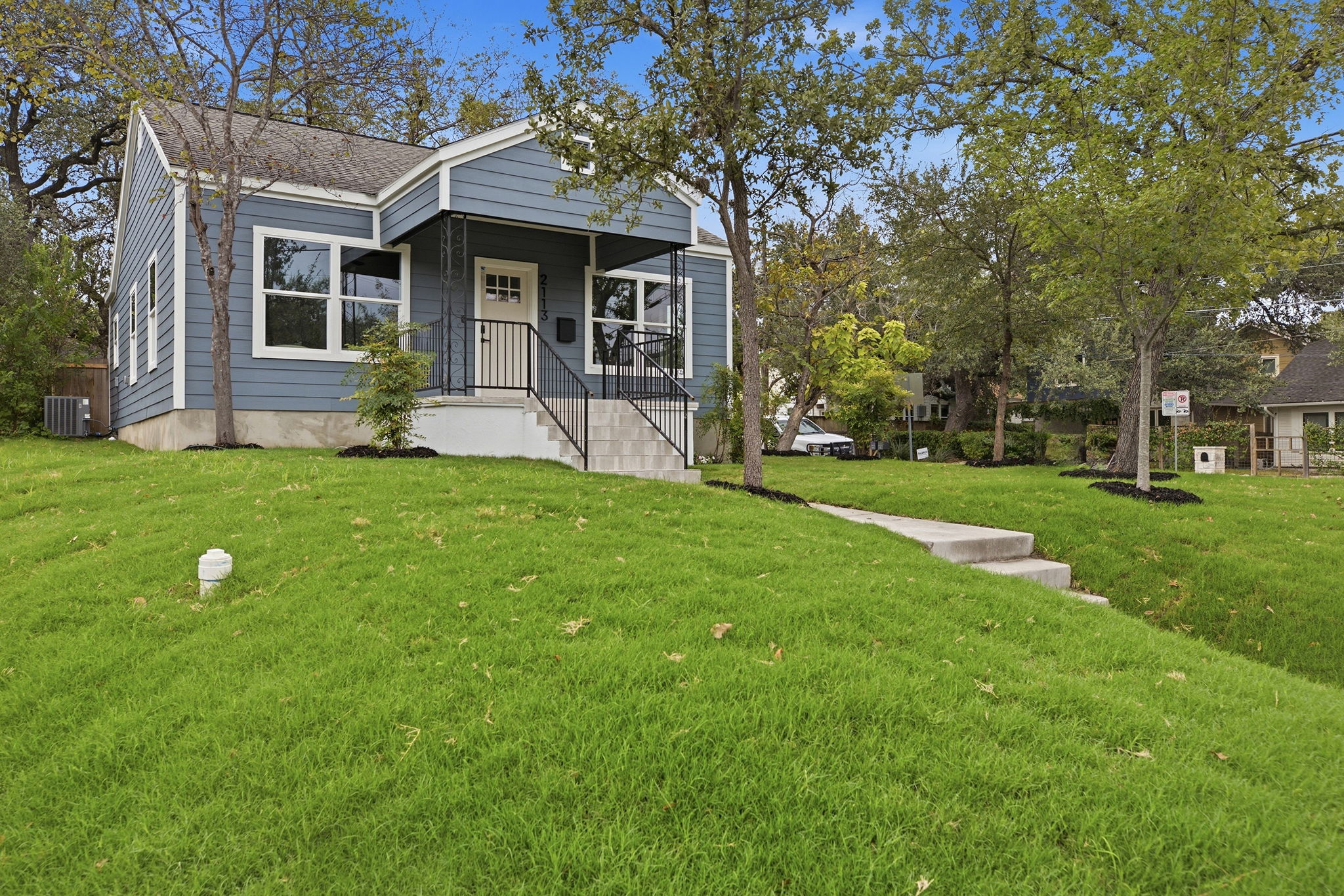 Front of the home from the street with a landscaped lawn