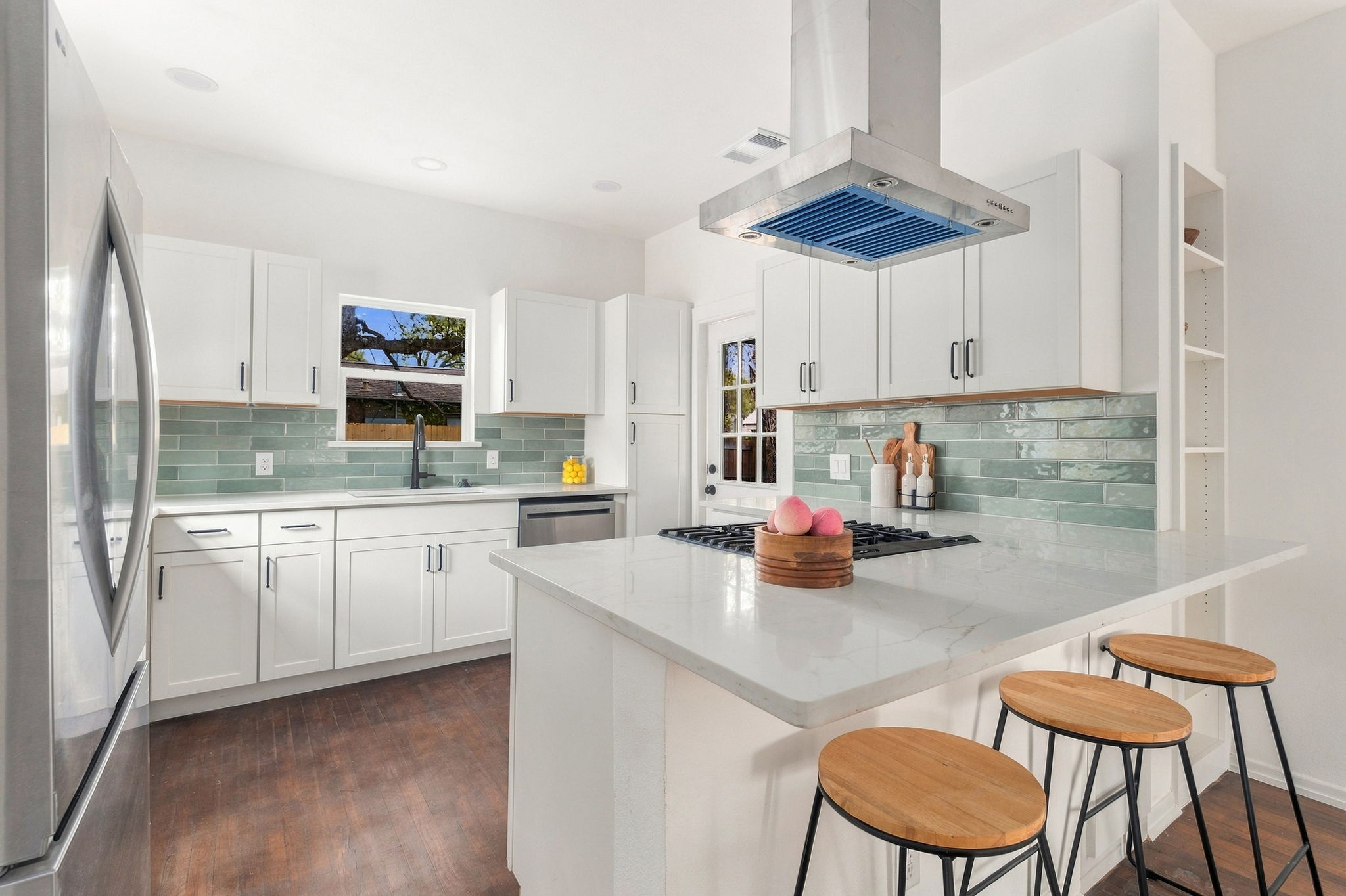 Kitchen peninsula with a gas range, quartz counters and bar seating