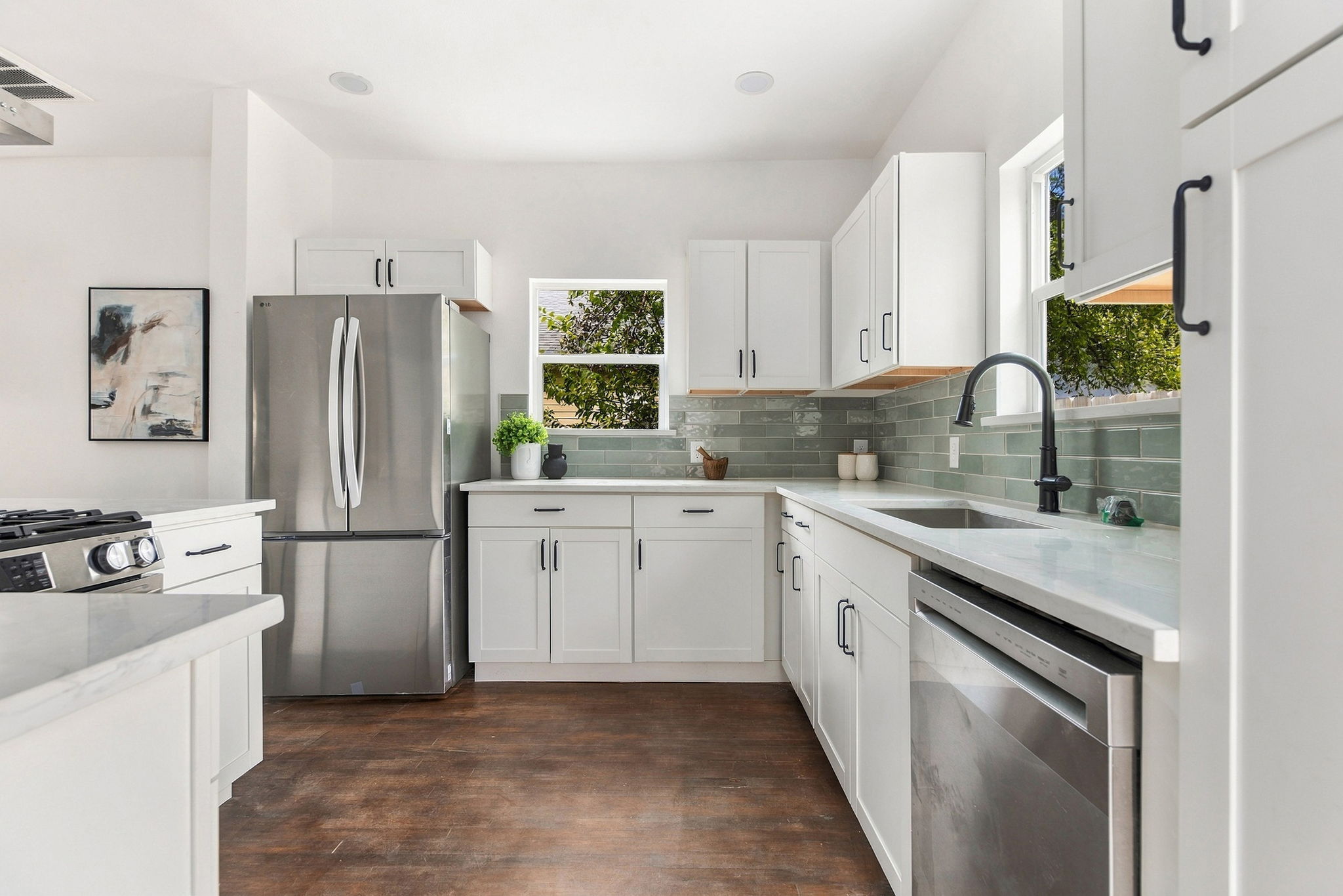 Kitchen sink wall with a stainless dishwasher and refrigerator