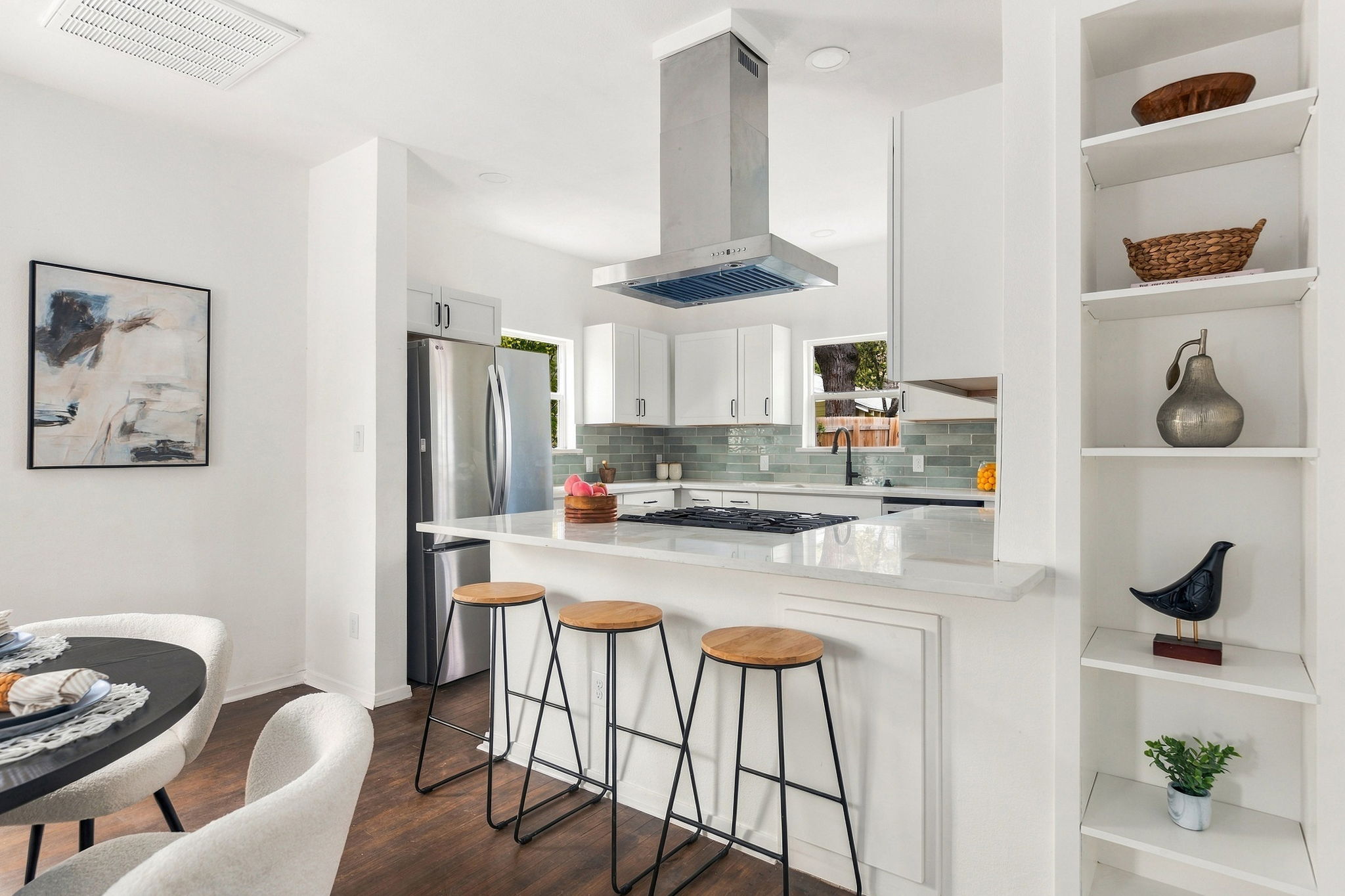 Kitchen with built-in open shelving and a stainless refrigerator