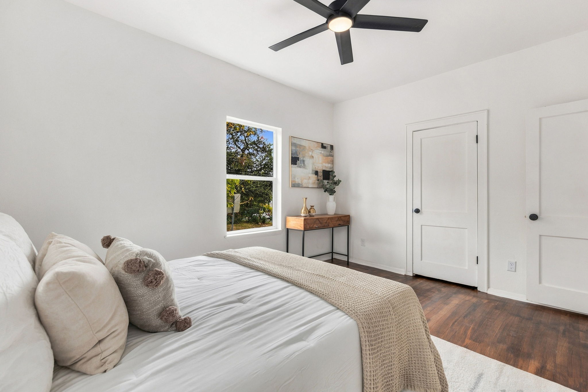 Primary bedroom with a ceiling fan and window