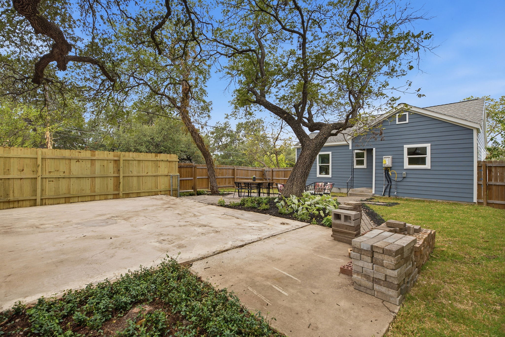 Backyard looking toward the home across the concrete parking pad