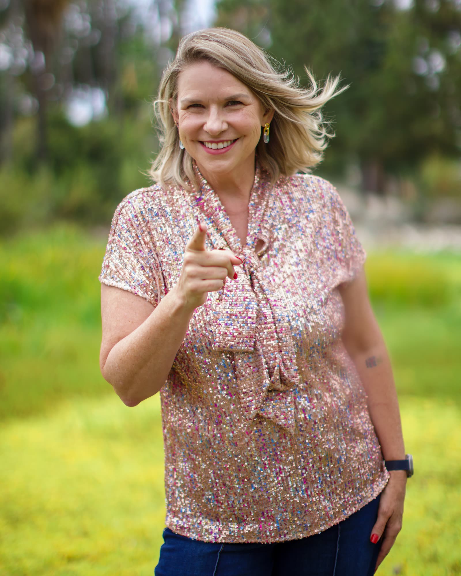 Dori Etter smiling and pointing toward the camera