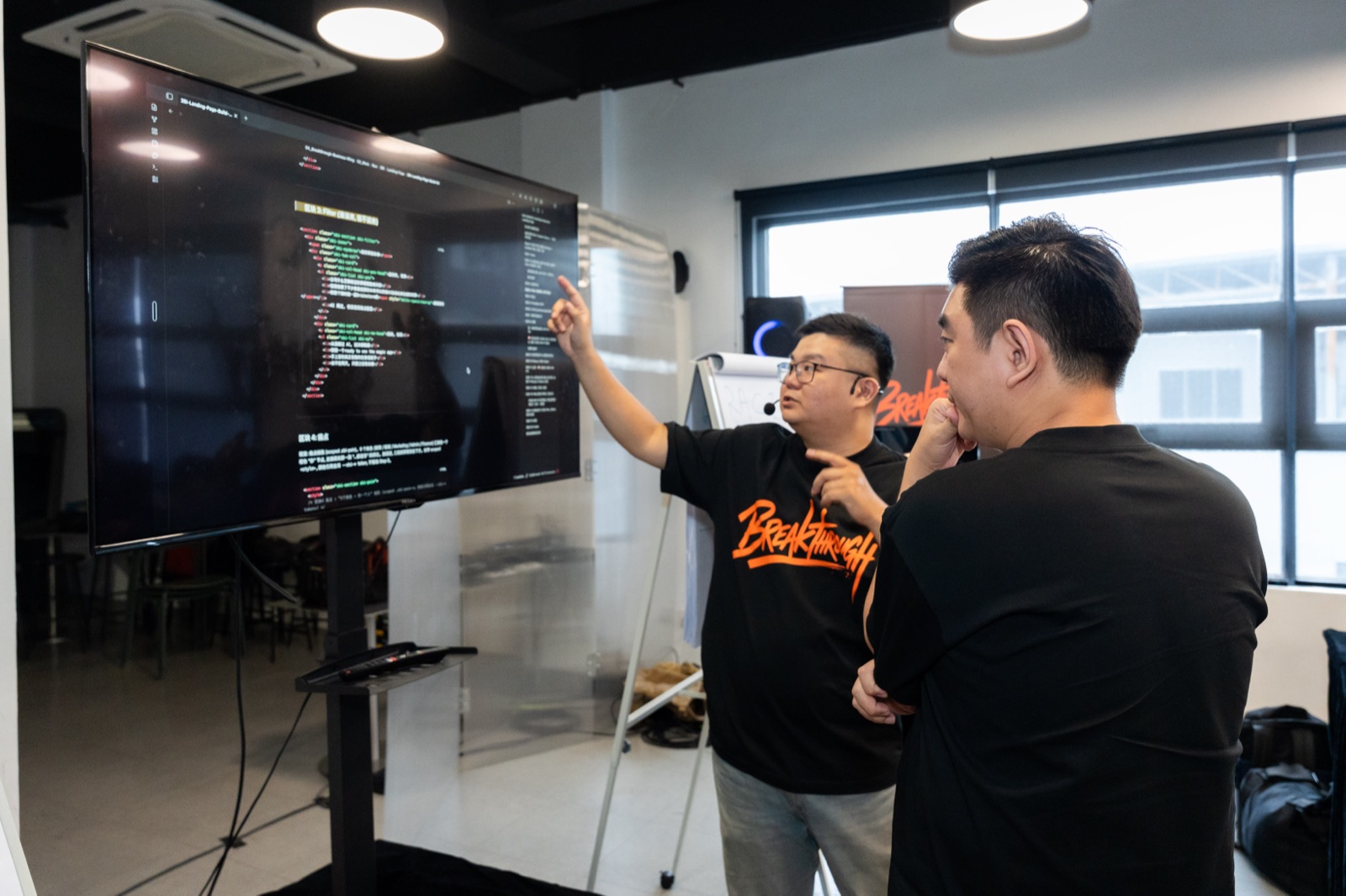 Jia Wei 走到学员旁边, 一起看他屏幕上的程式码