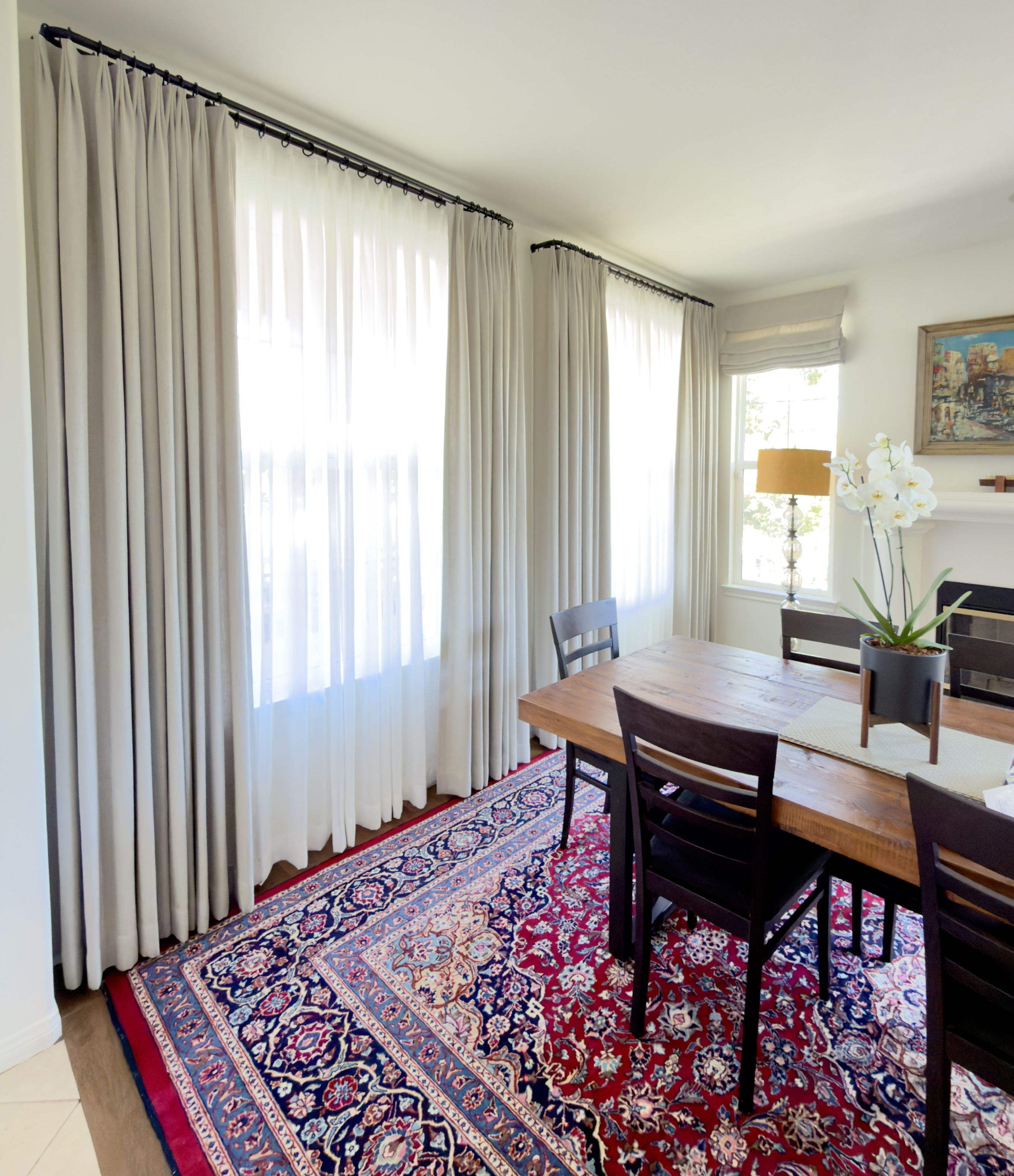 Custom drapes and sheer curtains installed on tall windows in Thousand Oaks dining room, black curtain rods and neutral fabric panels Custom drapes and sheer curtains installed on tall windows in Thousand Oaks dining room, black curtain rods and neutral fabric panels