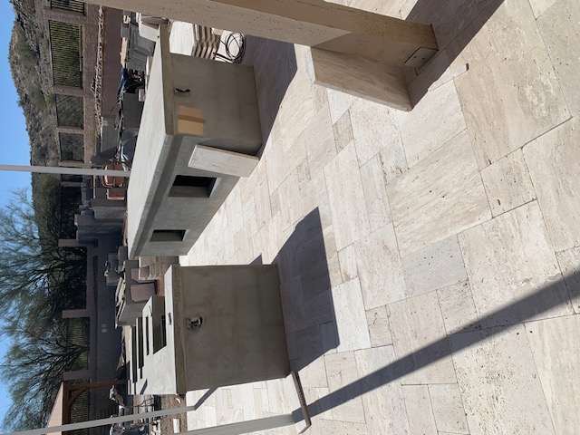 Before — outdoor kitchen under construction with workers on site