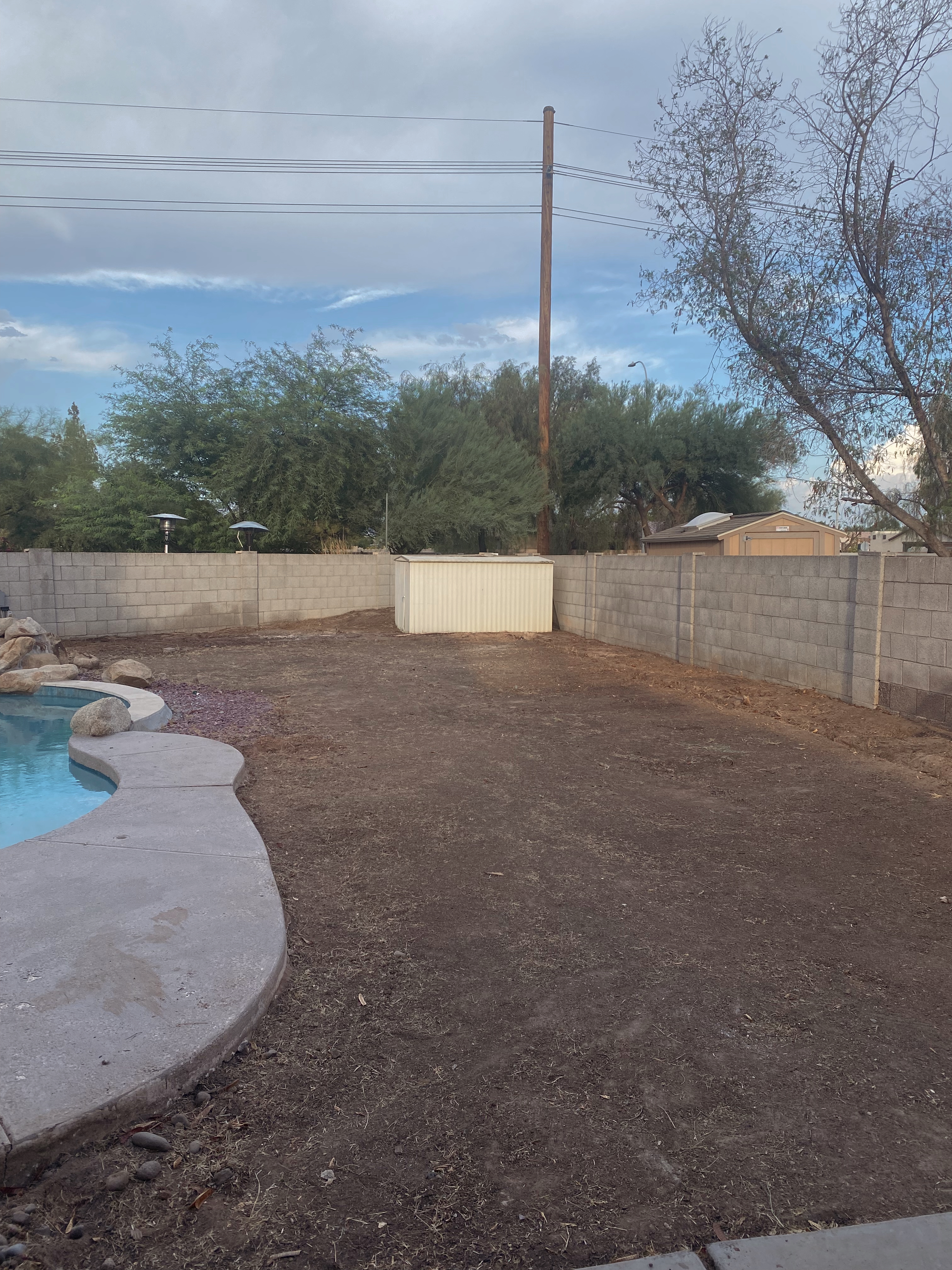 Before — bare dirt lot with pool excavation