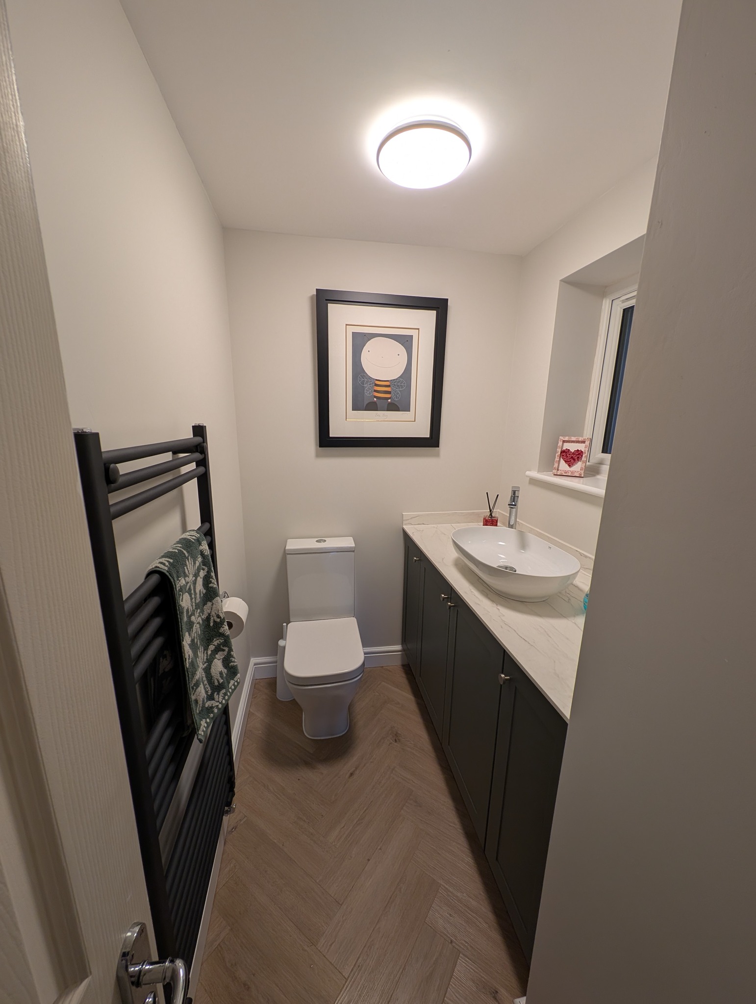 Completed bathroom with green tiling and gold fittings
