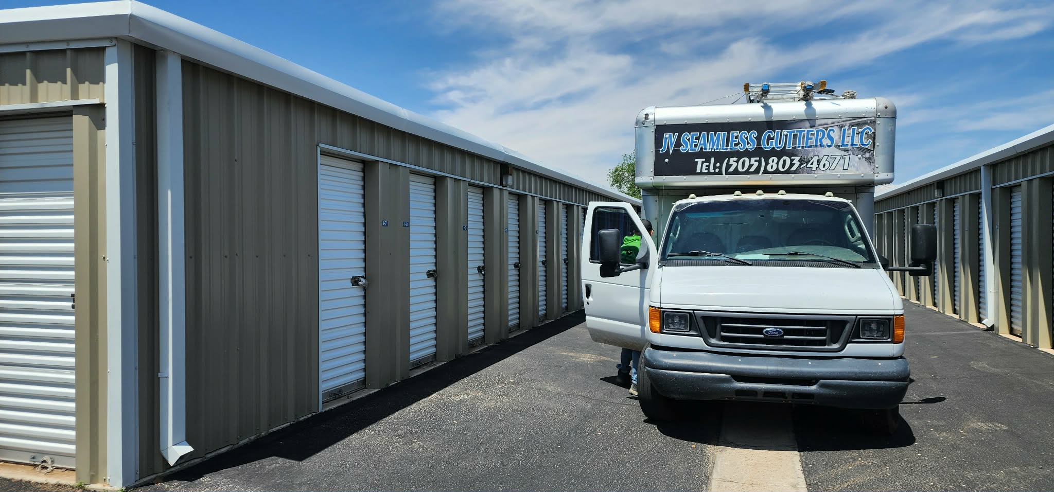 Company box truck parked beside storage buildings