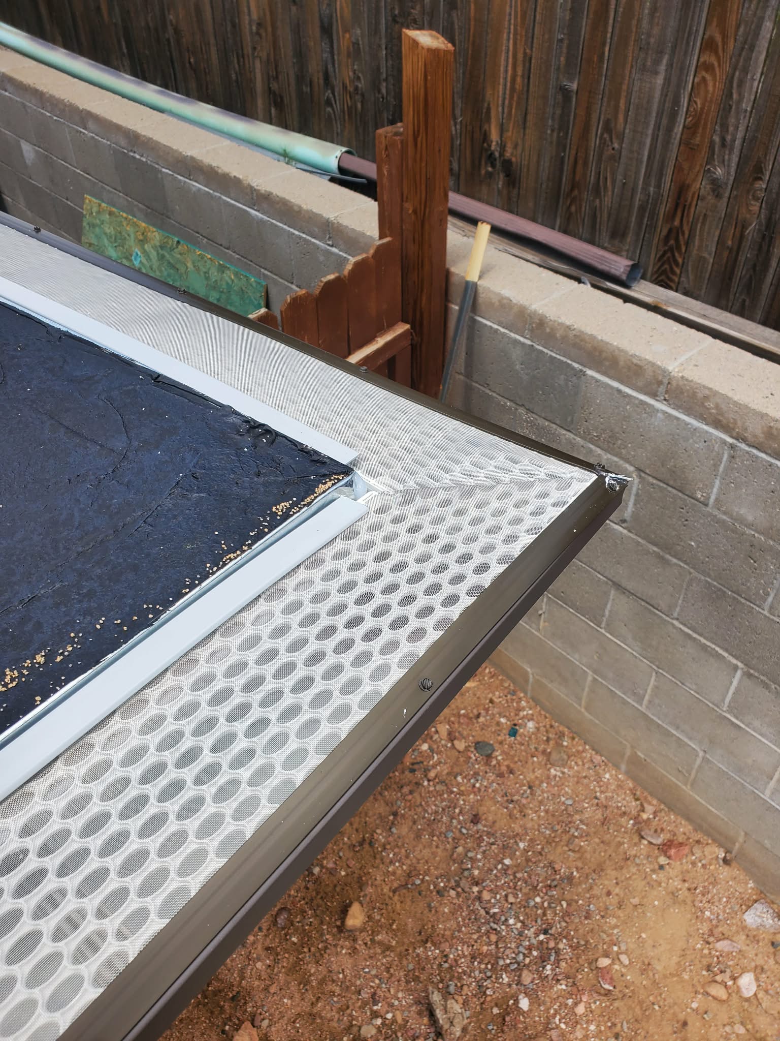 Gutter guard installation along the roof edge of a home