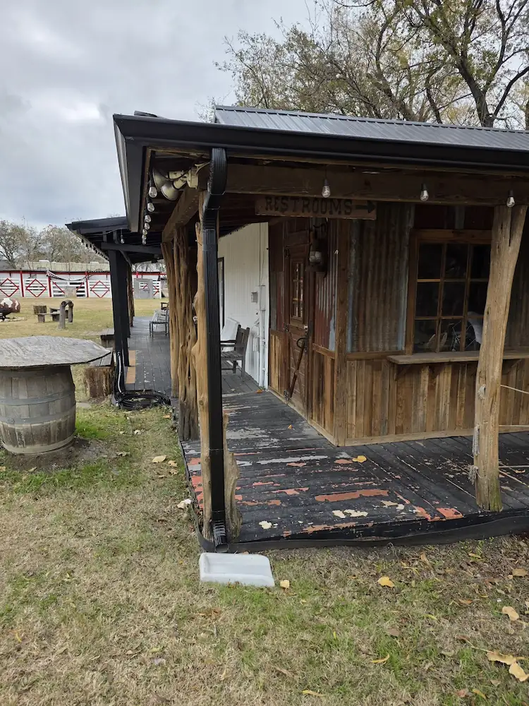 Rustic wood-sided porch with a metal roof edge and gutter