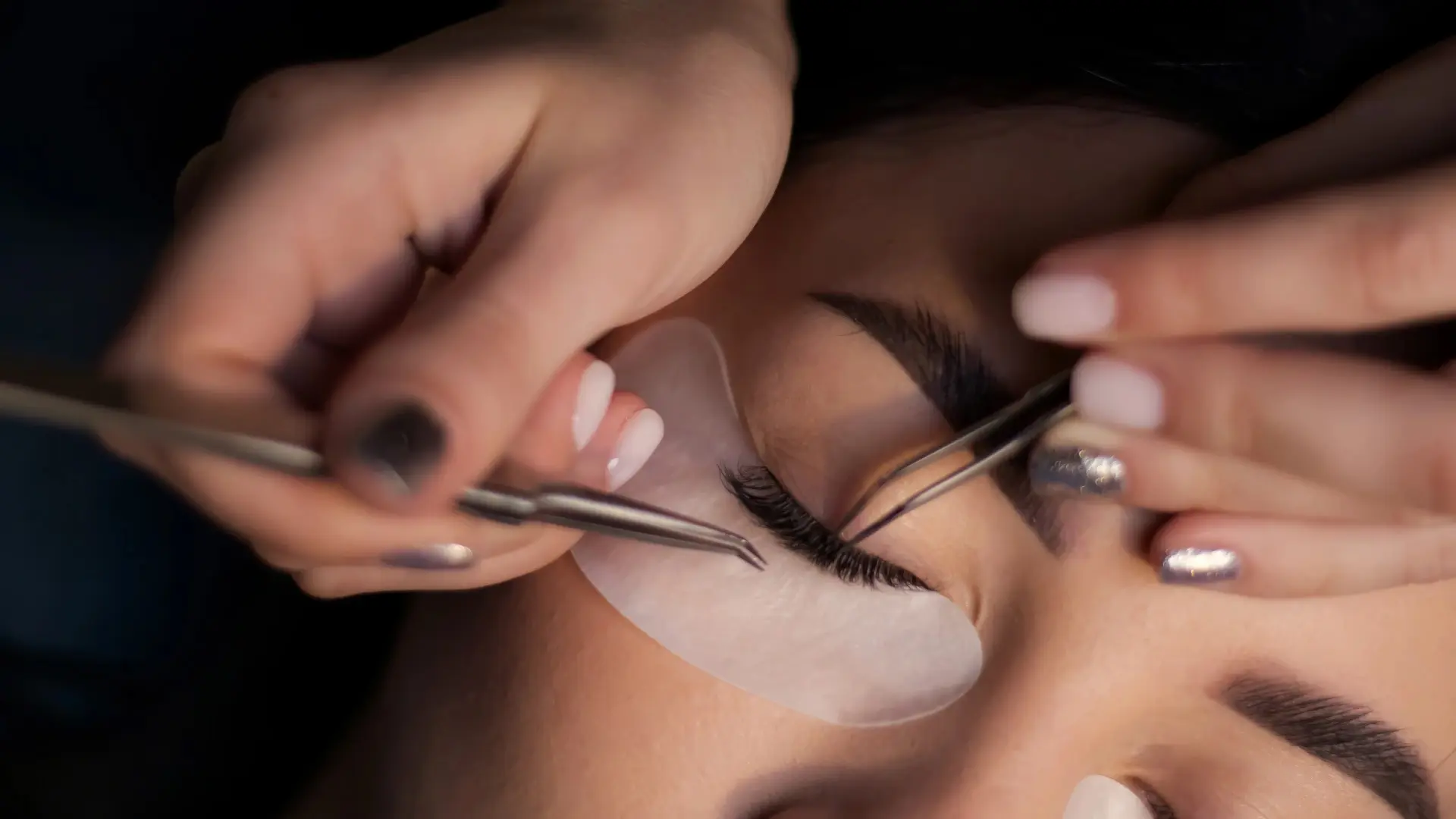 A technician working on a guest's eyelash extensions