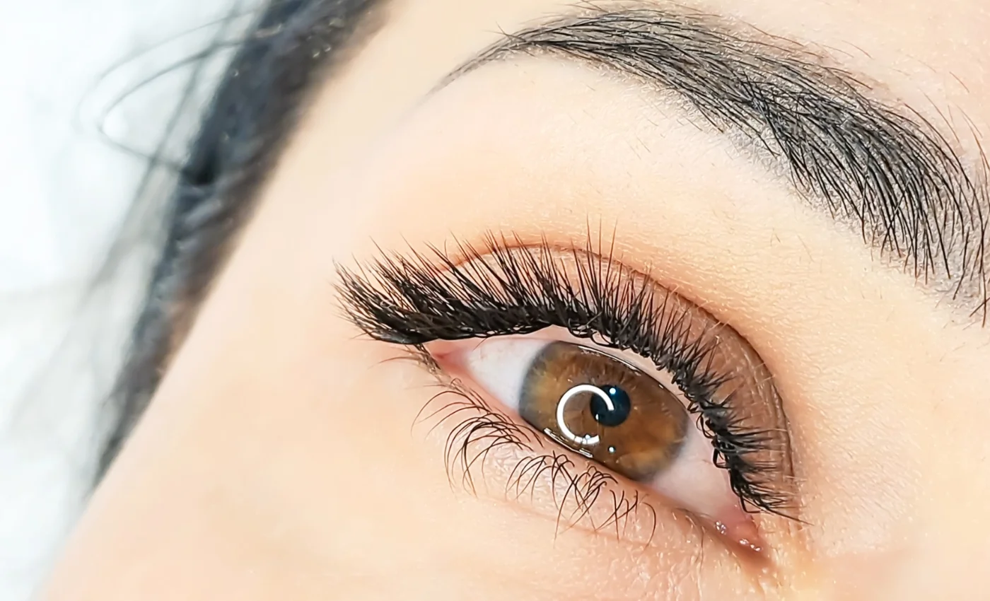 A technician refreshing classic lash extensions during a refill