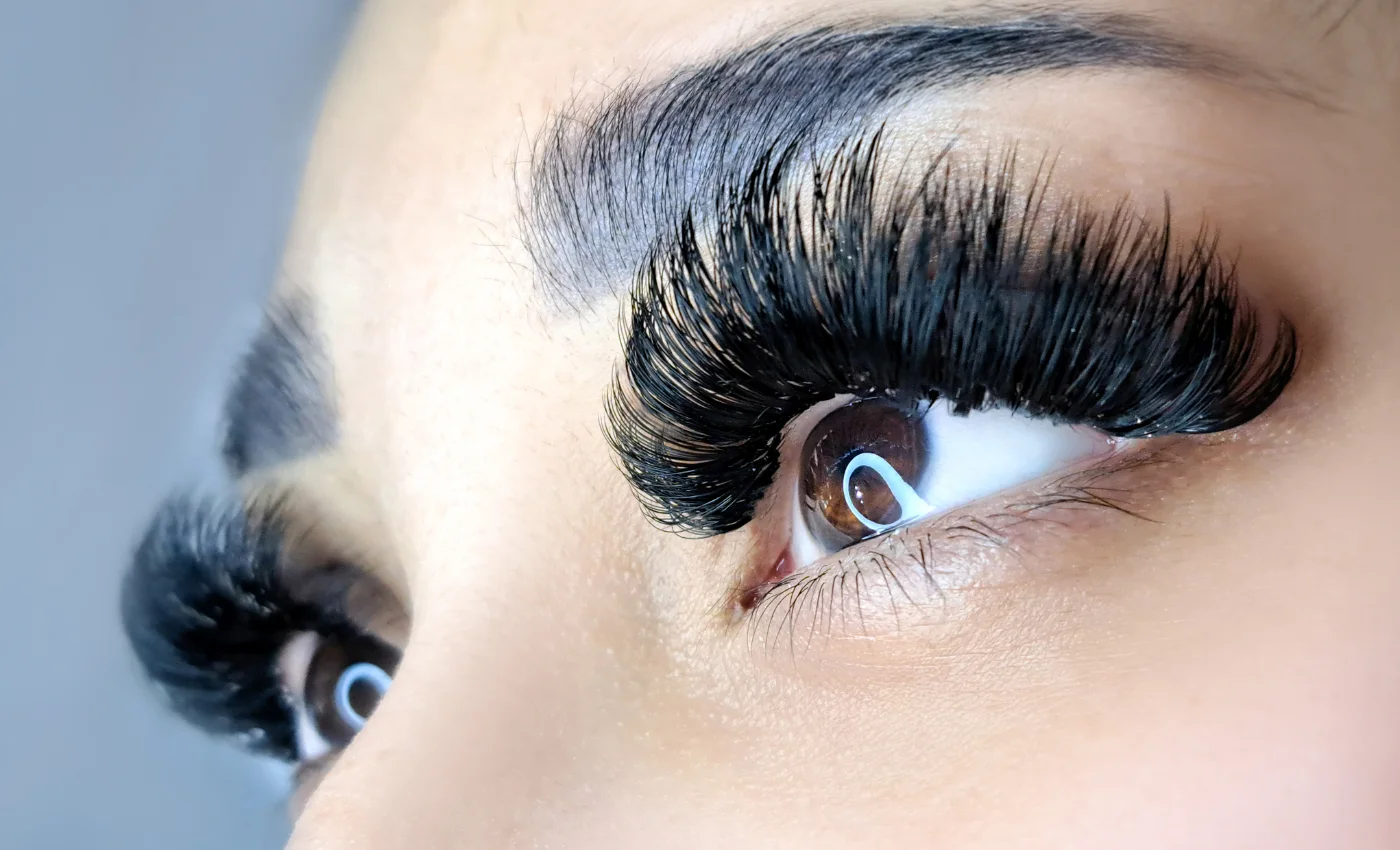 A technician applying volume lash extensions
