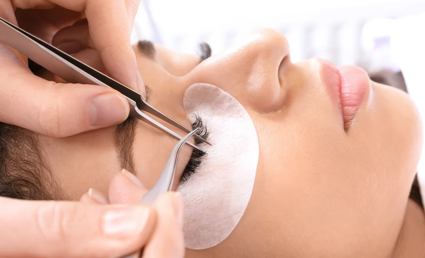 A technician refreshing hybrid lash extensions during a refill