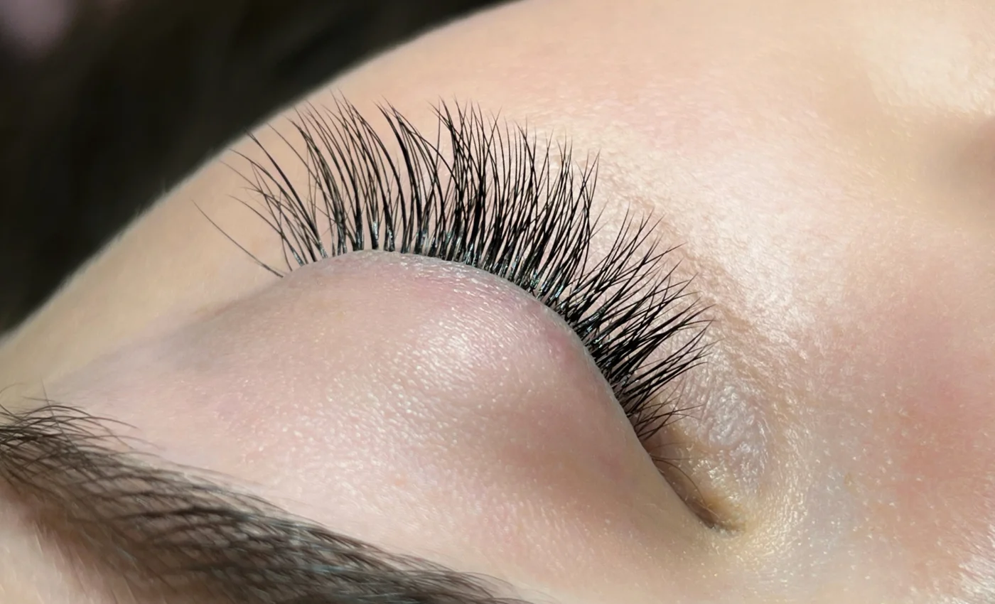 A client showing soft full hybrid lash extensions