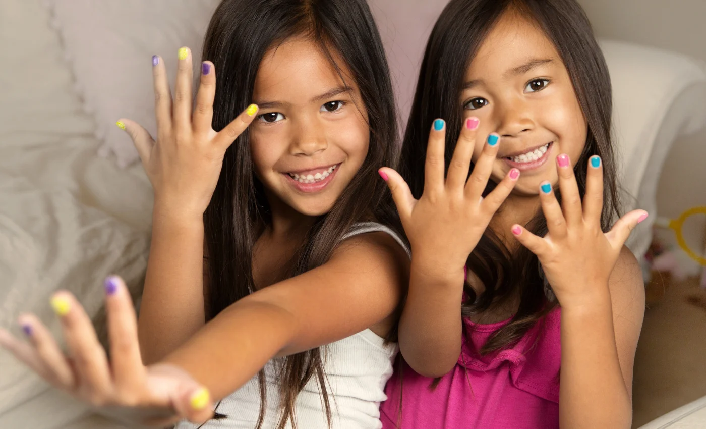 A younger guest showing freshly polished nails after a junior manicure