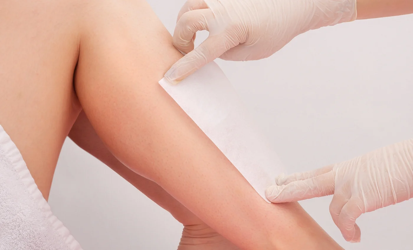 A technician performing a half leg waxing service