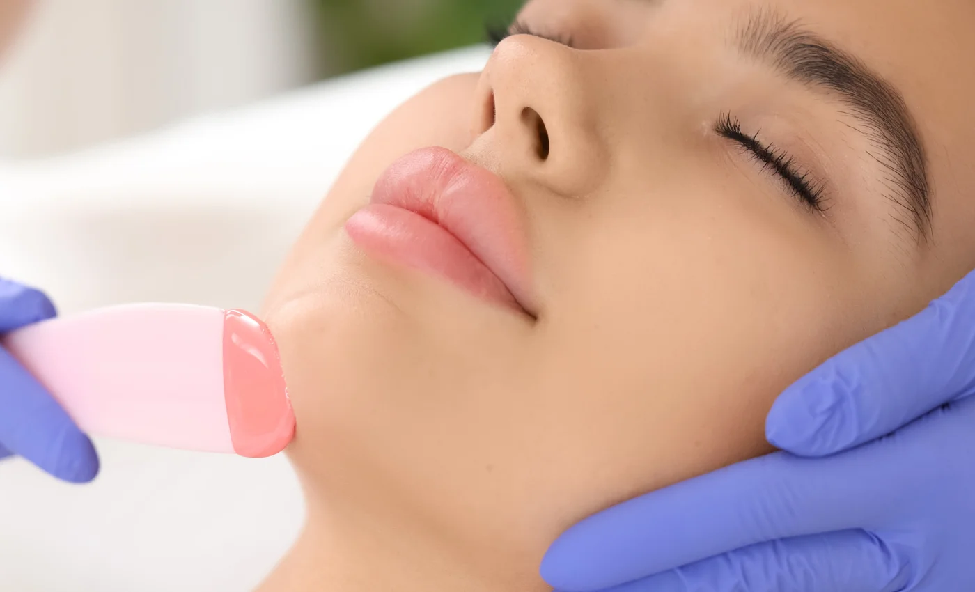 A technician performing a chin waxing service