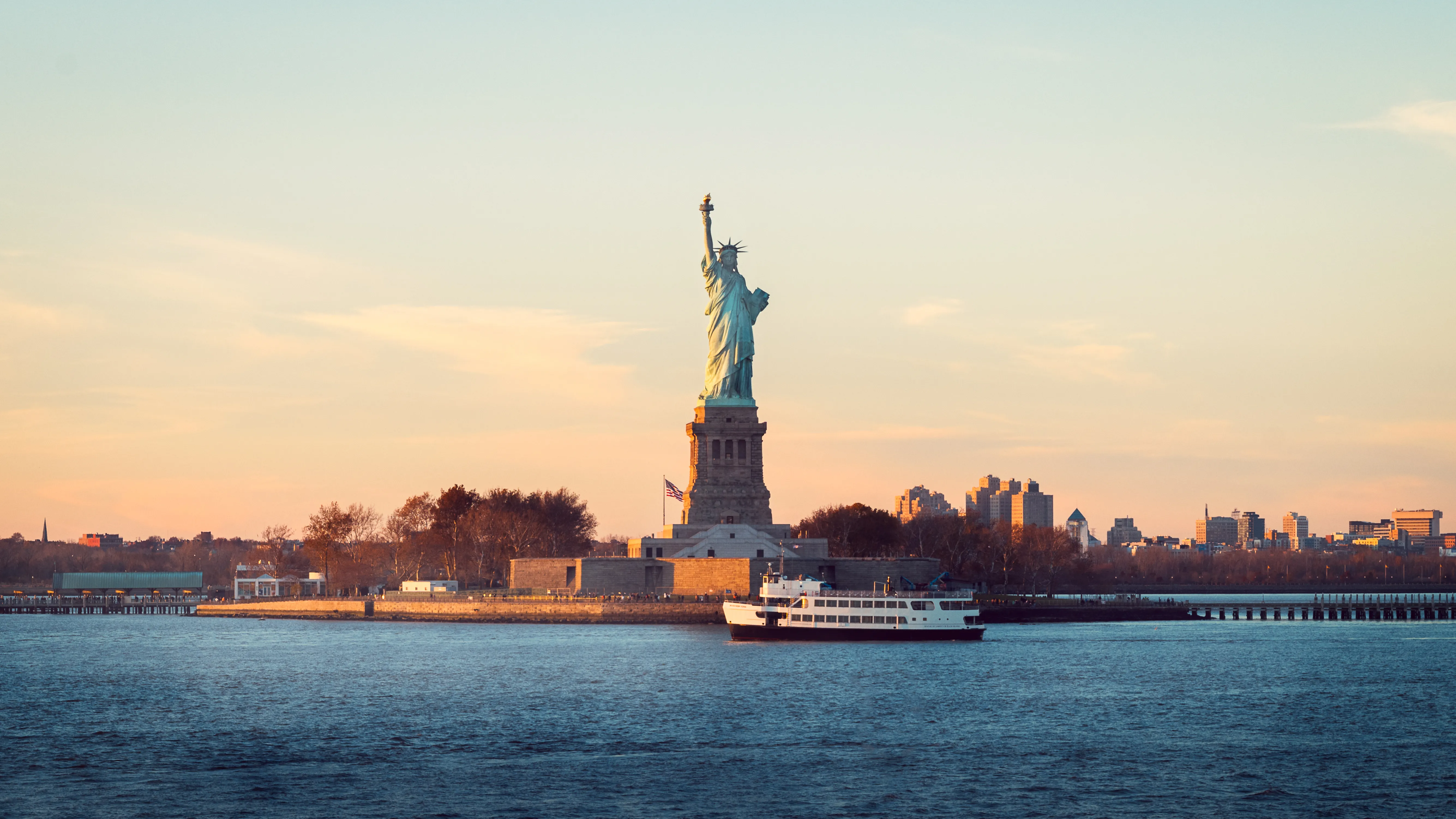 Statue of Liberty at sunset in New York Harbor.