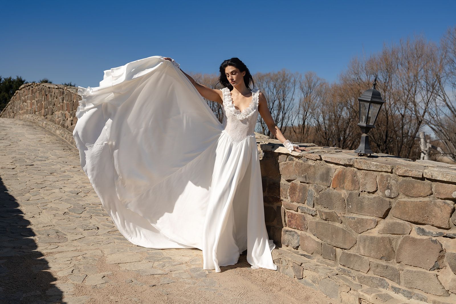 The Vesper with its skirt lifted in the breeze against a stone wall