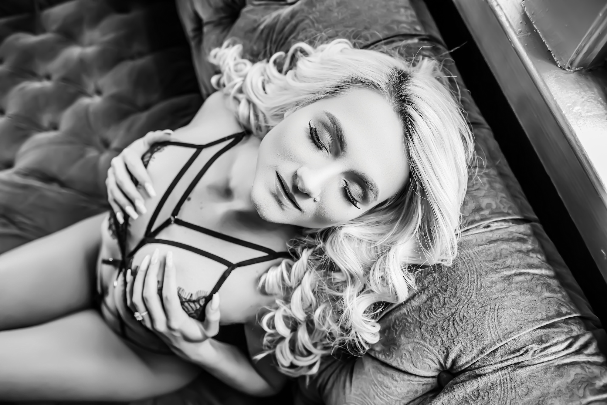 woman laying on fur rug, wearing black and blue lingerie