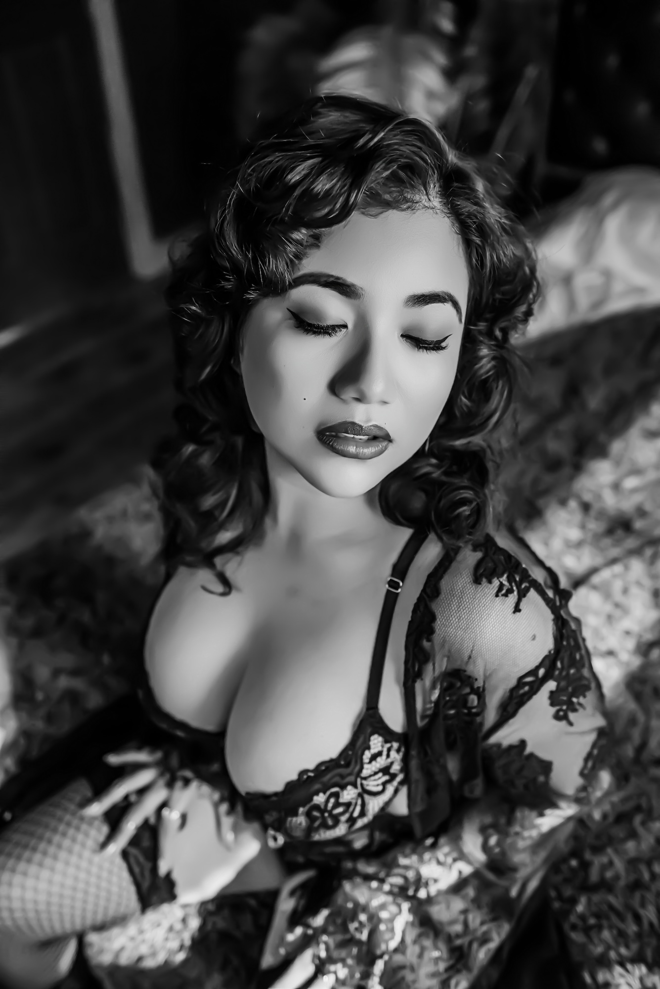 woman lounging on grey couch, wearing black lingerie