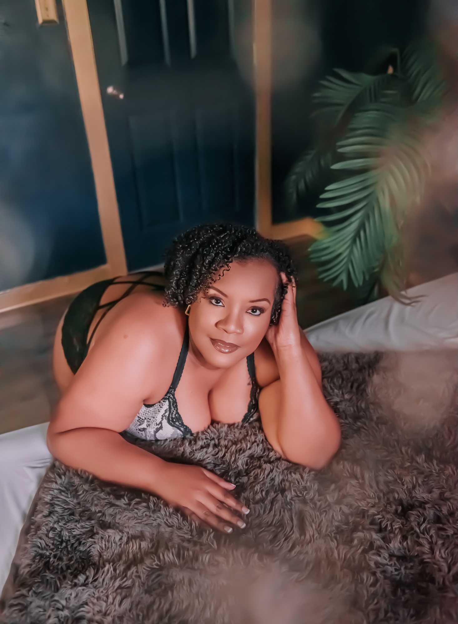 woman laying on bed with fur blanket covering her