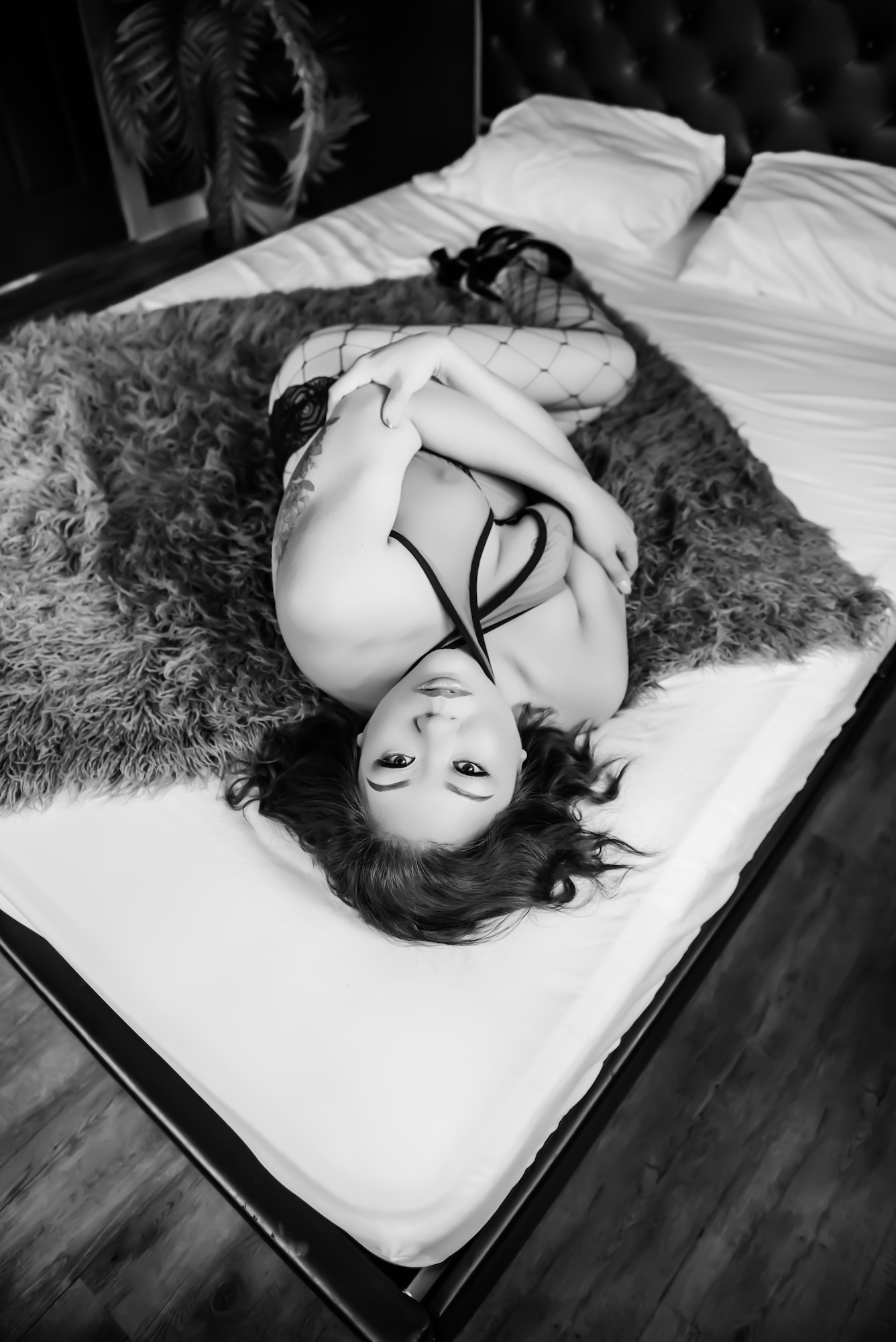 woman standing beside window wearing black, see-through lingerie