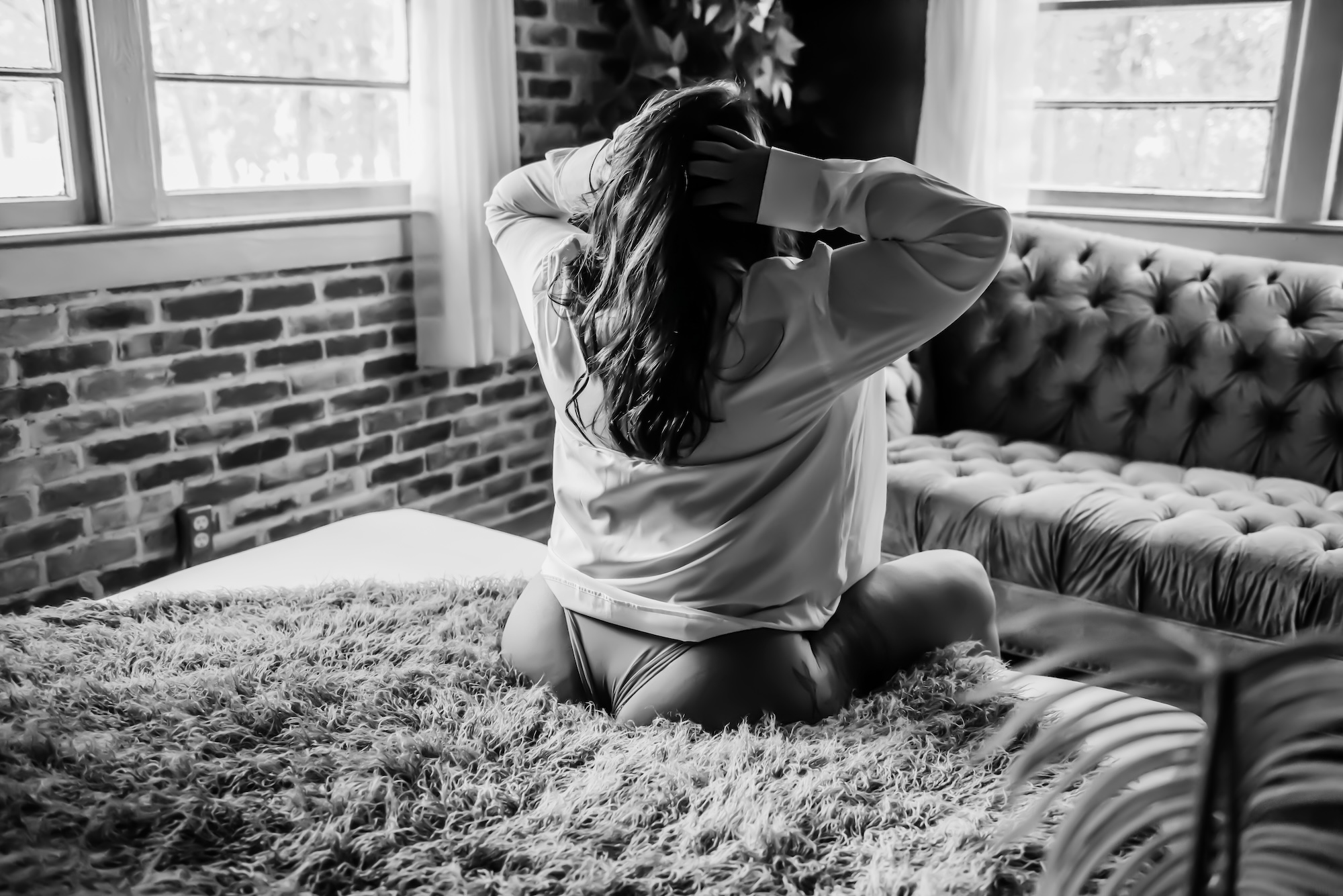 photo of red-haired woman holding a bouquet while lounging on couch