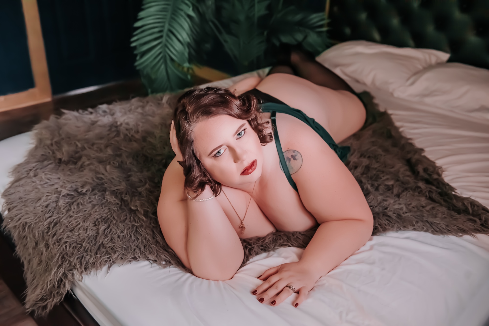 woman in pink and black lingerie kneeling on couch