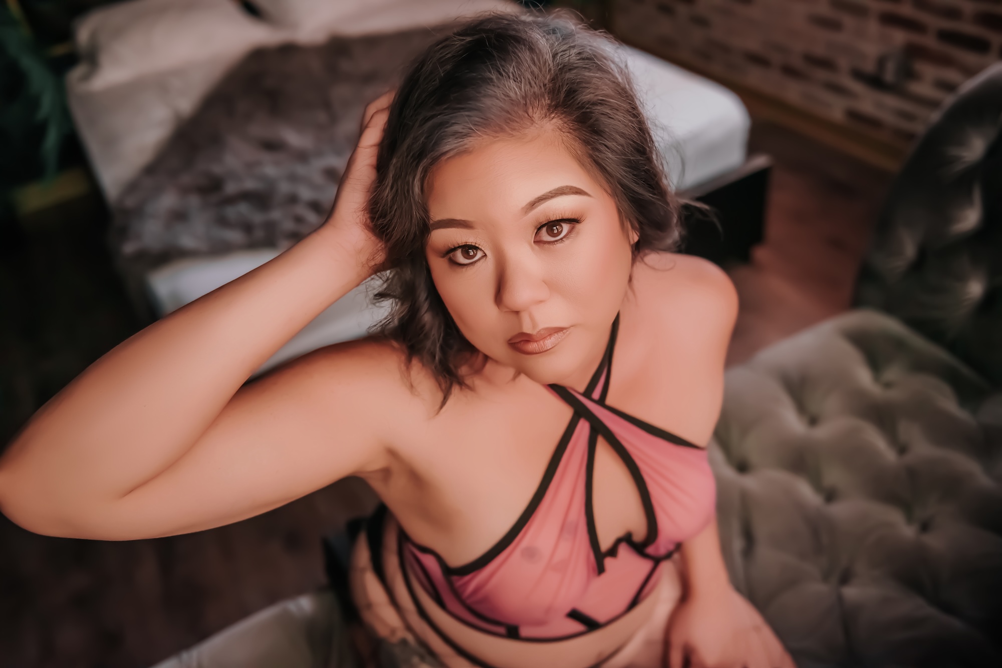 woman laying back on bd in black lingerie