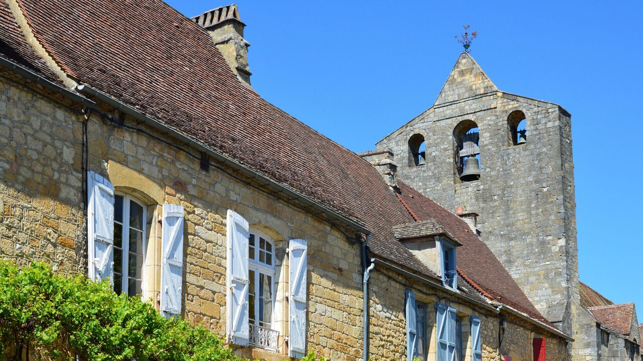 Stone building with blue shutters in France