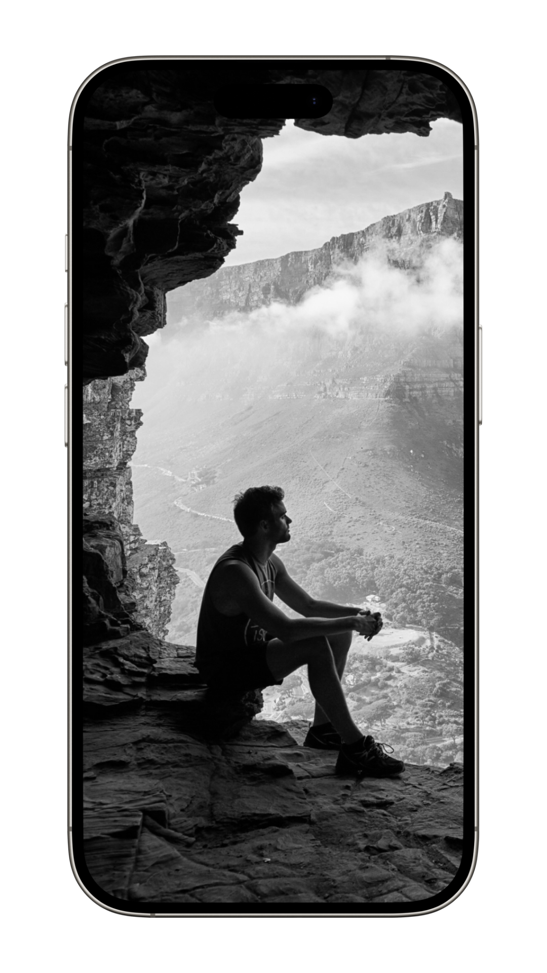 Man sitting in a cave overlooking mountains, symbolizing self-reflection, clarity, and the journey of personal transformation through Adam Feuerstein’s coaching on sovereignty, truth, and spiritual integration