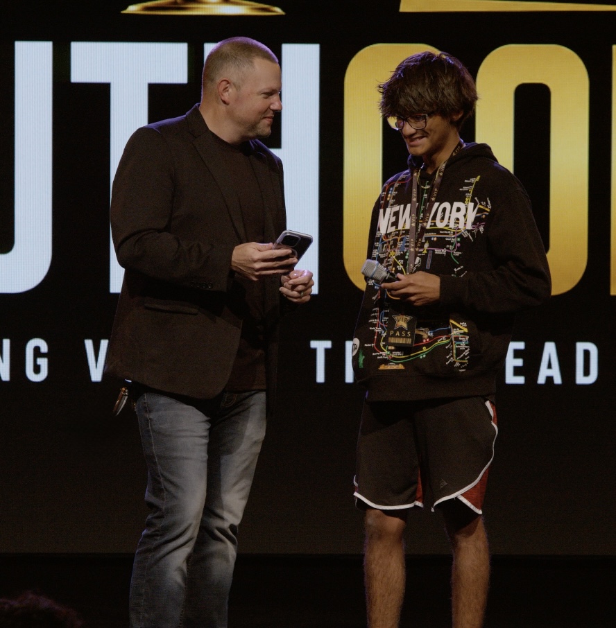 Matt Adkins with a student he coached, on stage at a YouthCon event