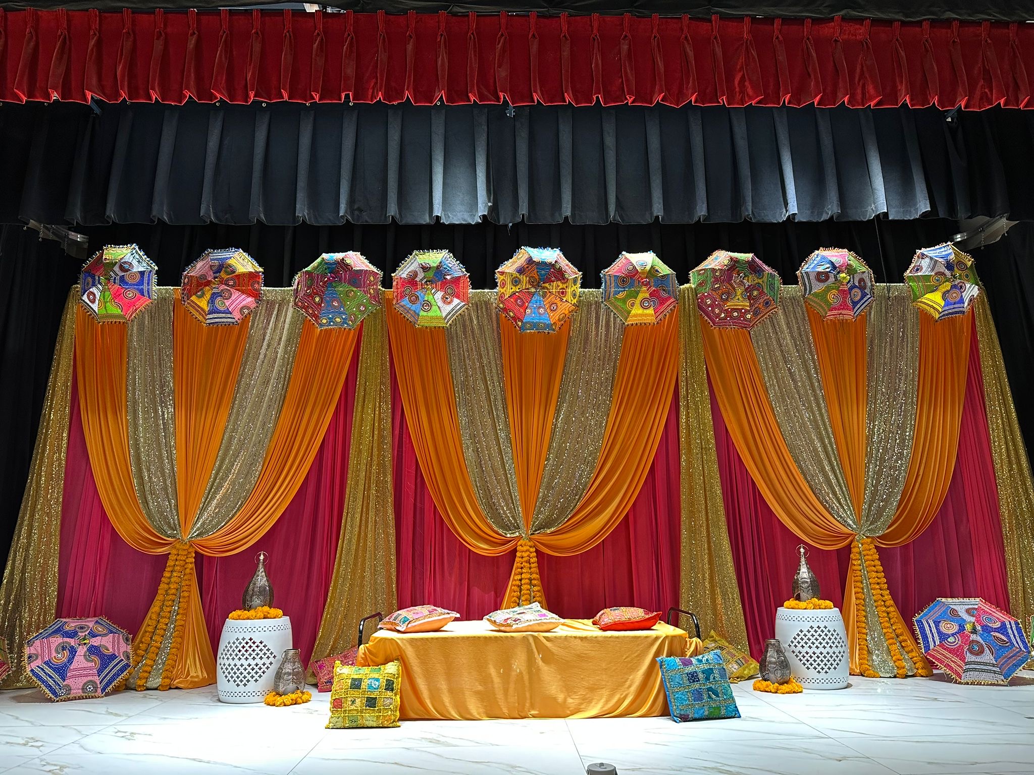 An orange and red draped stage in the ACCA hall