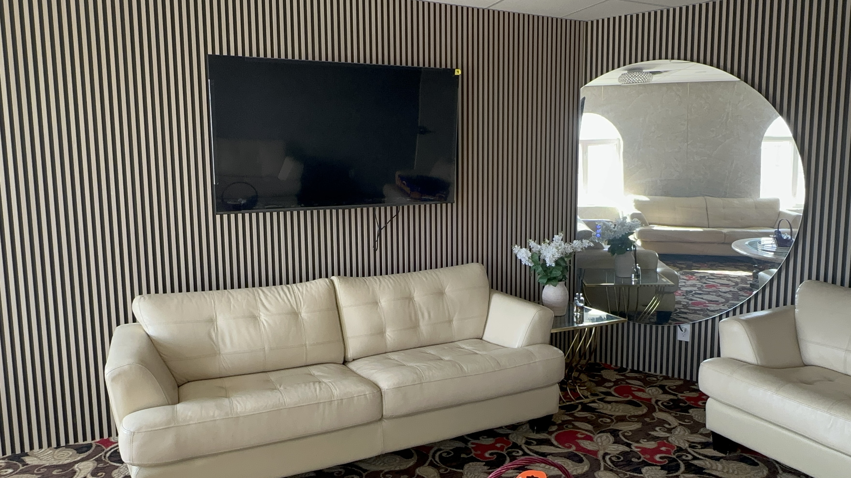 A private lounge with cream seating and a wall-mounted screen