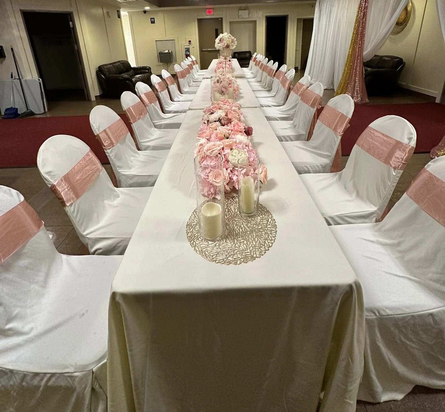 A long banquet table dressed with blush sashes and floral centrepieces