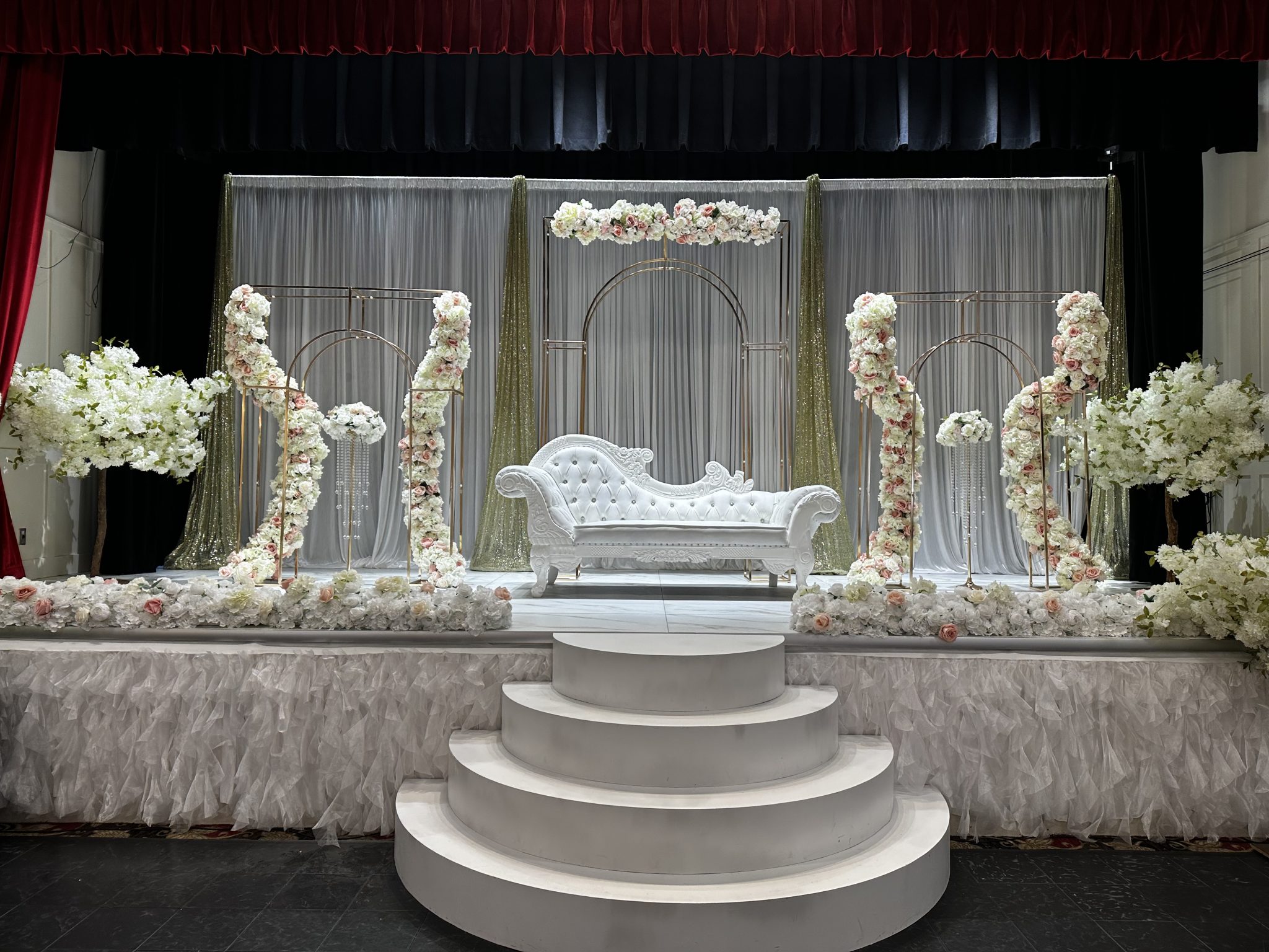 A white and silver stage with sculpted floral columns