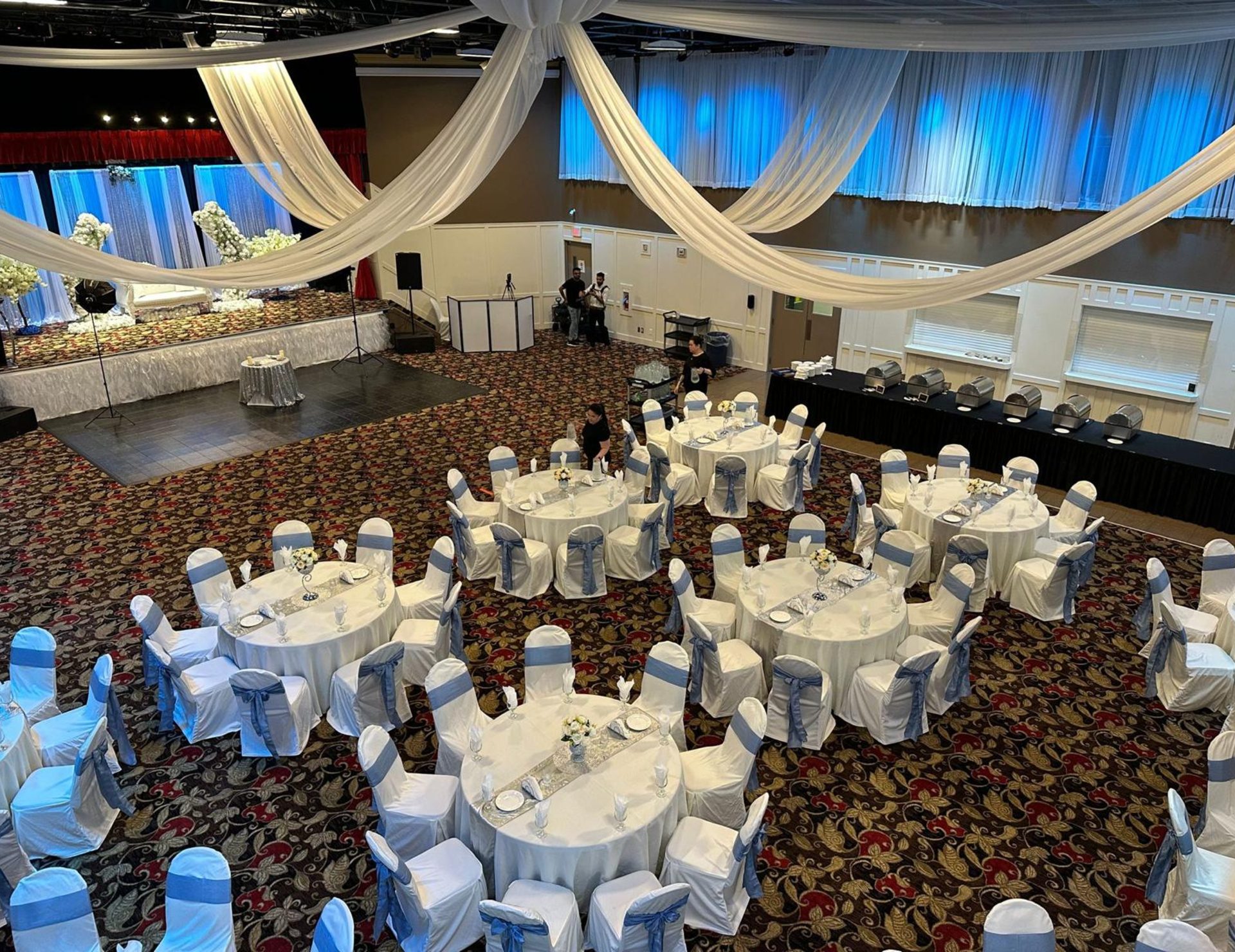 The main hall from the balcony showing the parquet dance floor, rounds with blue sashes and the buffet line