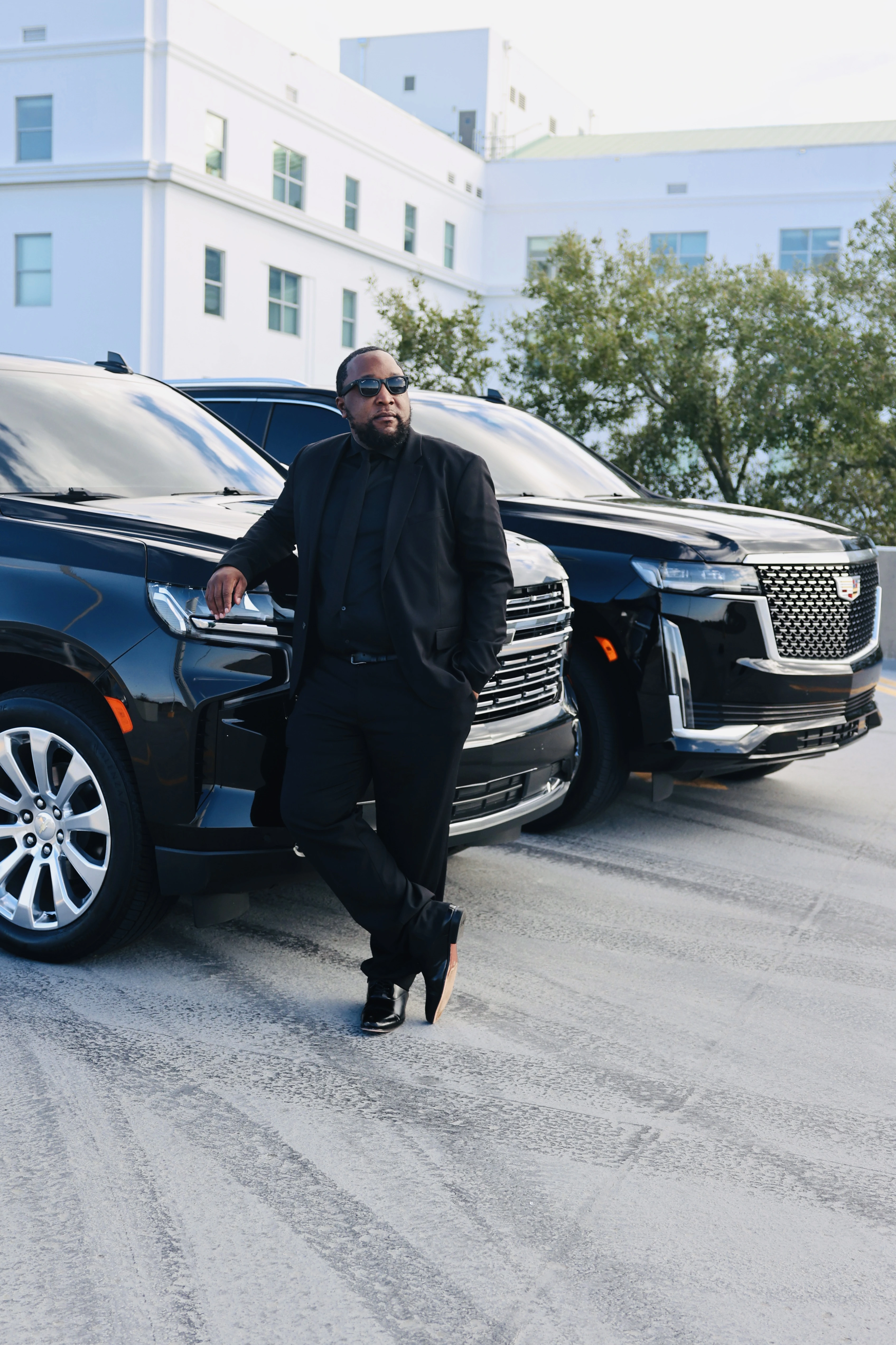 Musa, owner of 850 Black Truck, standing beside the black SUVs