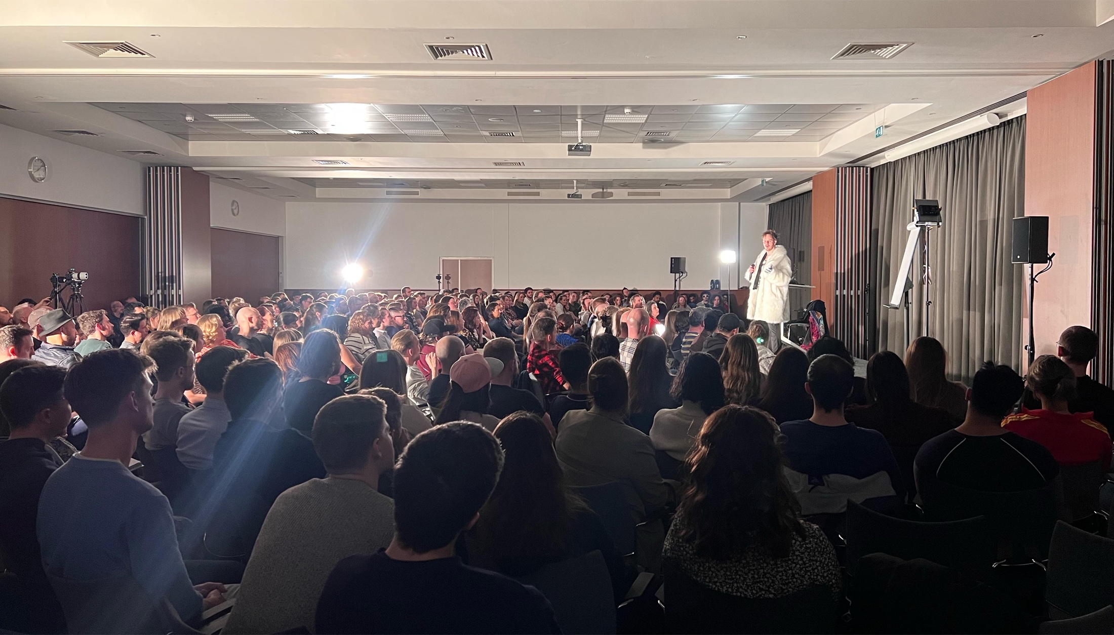 Julien Blanc speaking to a full audience at a live event