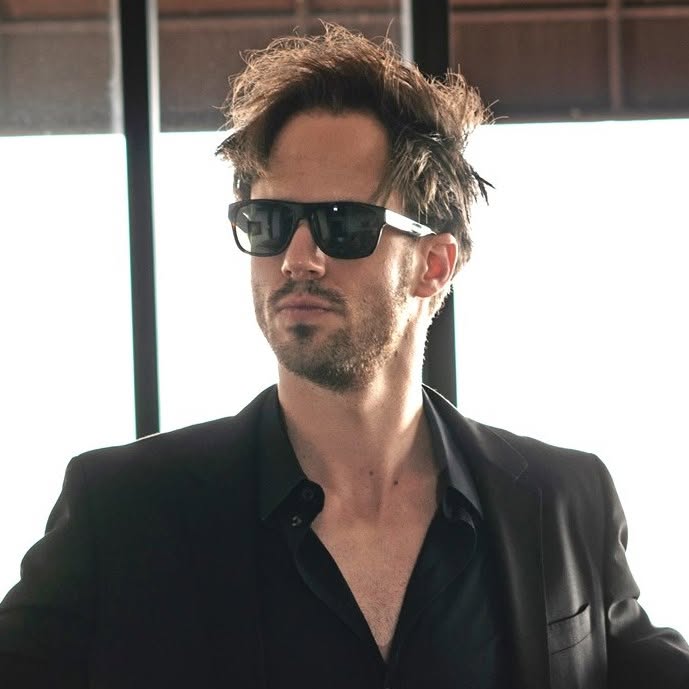 Portrait of Julien Blanc wearing sunglasses and a black blazer