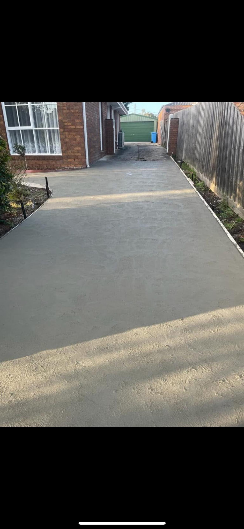 Concrete driveway running beside a brick home